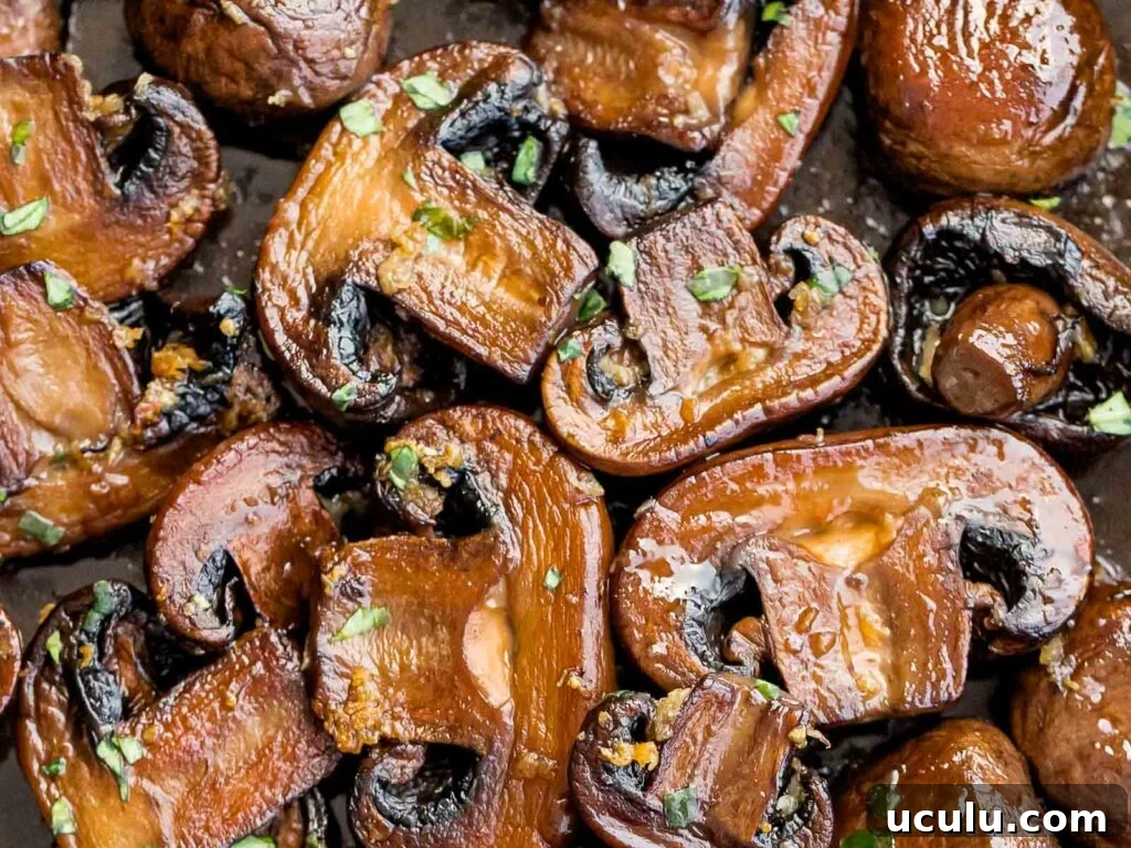 close up of twice cooked mushrooms with garlic butter and chopped parsley
