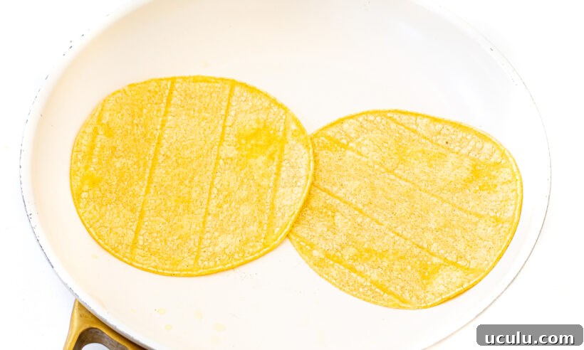 Two tortillas warmed up in a skillet.
