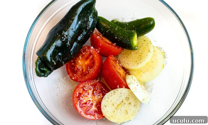 Veggies for roasted tomato chili salsa in a glass mixing bowl.