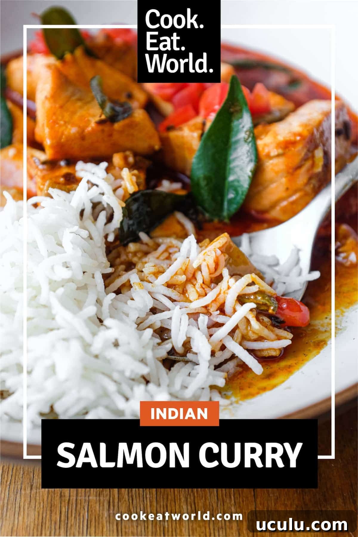 A bowl of Indian Salmon Curry and rice decorated with fresh curry leaves, tomato and a drizzle of coconut cream