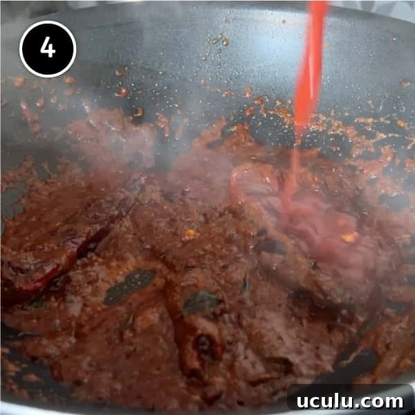 Tomato being added to a simmering curry paste