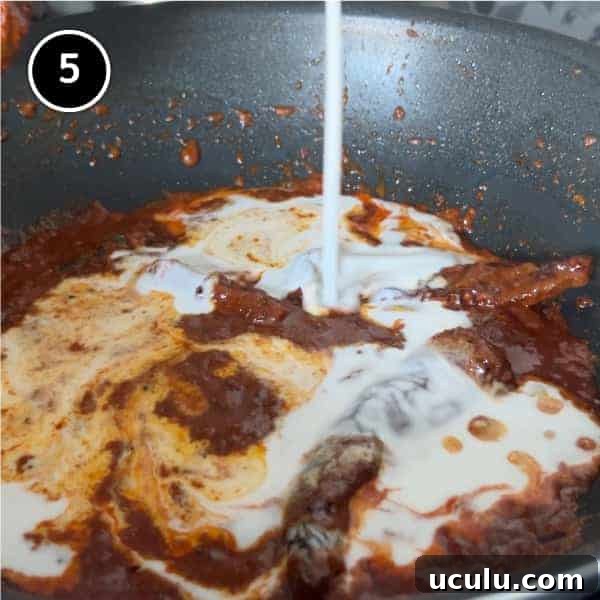 Coconut milk being added to a simmering curry paste