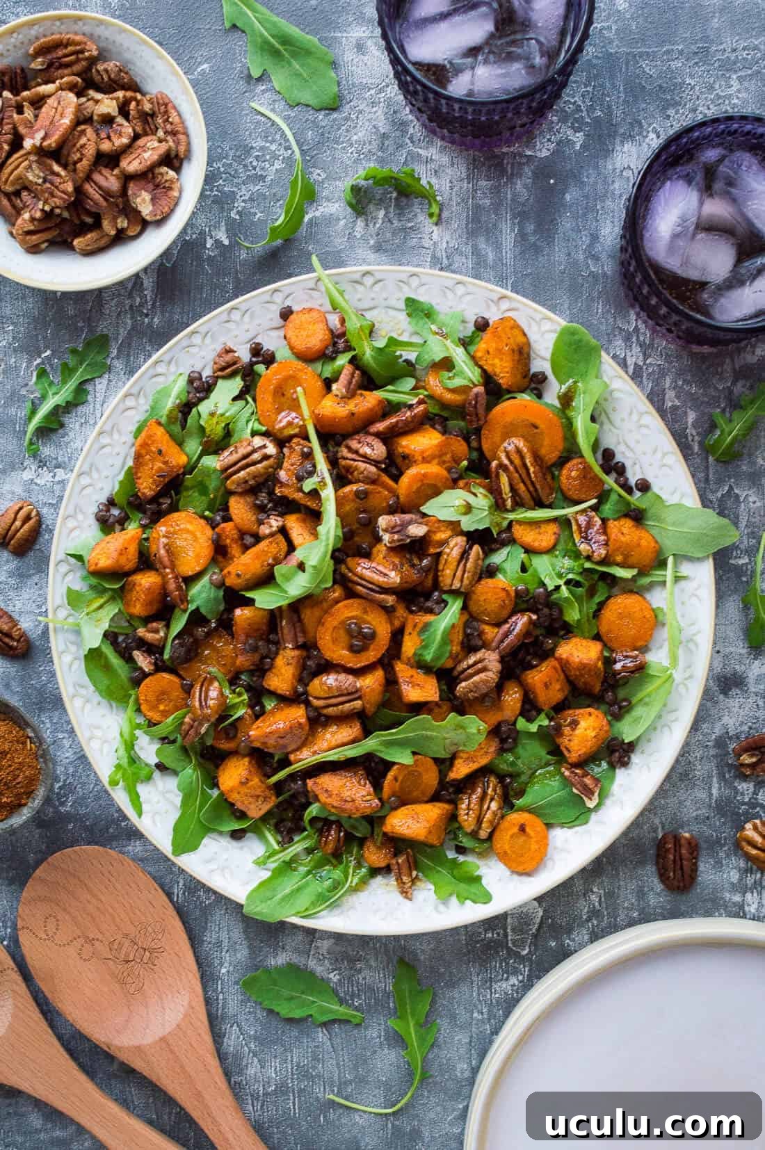 A plate of vegan roasted sweet potato, lentil and rocket salad with toasted pecans and pomegranate molasses dressing
