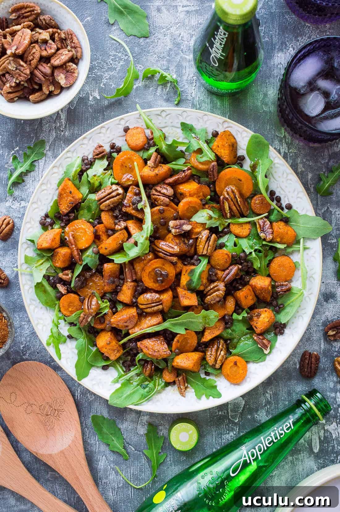 A white platter of roast sweet potato, puy lentil, rocket (arugula) and pecan salad with Appletiser