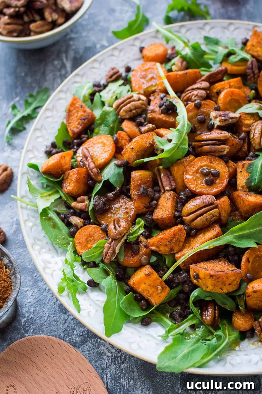 Side shot of roasted sweet potato, puy lentil, rocket (arugula) and pecan salad with pomegranate molasses dressing