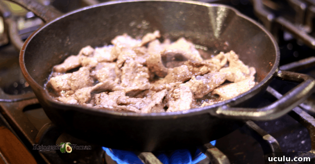 steak frying in cast iron pan over a flame