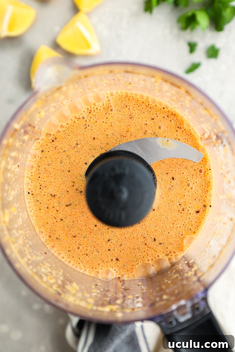 A food processor filled with lemon garlic marinade for chicken wings