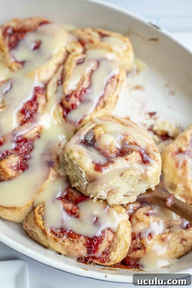 a strawberry roll on top of other rolls in a baking dish