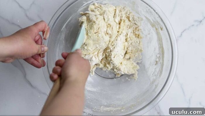 Stirring dough together with a teal silicon spatula
