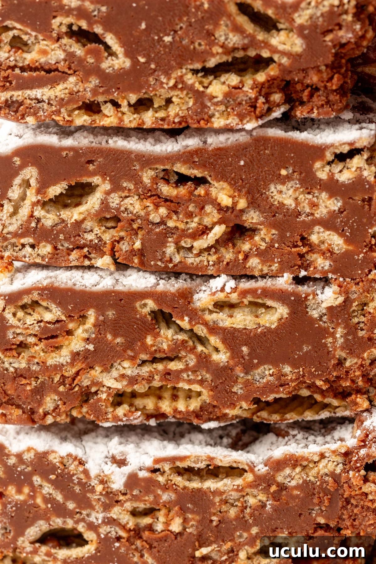 Tightly stacked puppy chow bars showing neat layers of cereal and smooth chocolate coating.