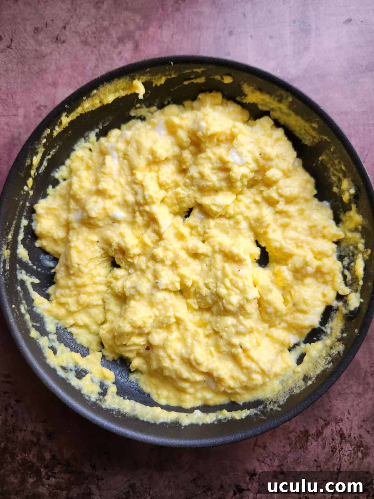 Cooked scrambled eggs in a pan.