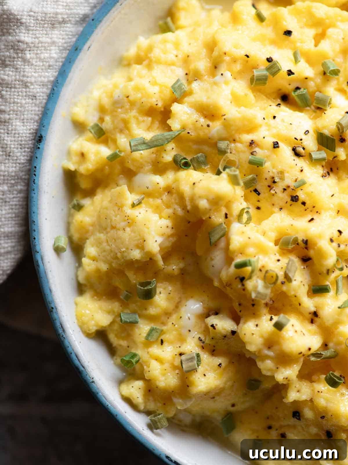 Overhead close-up of buttermilk scrambled eggs in a skillet.