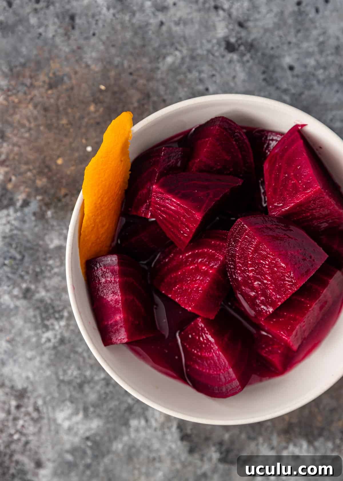 overhead closeup: a small white bowl full of sliced pickled beets