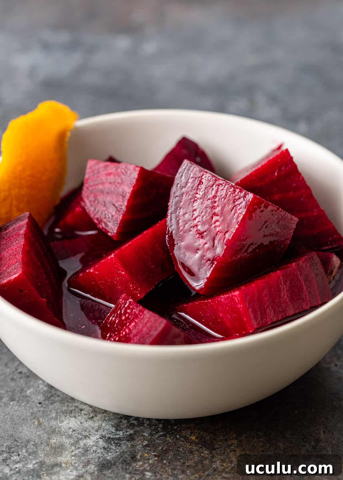 side view closeup: my pickled beets recipe in a bowl with an orange peel to the side