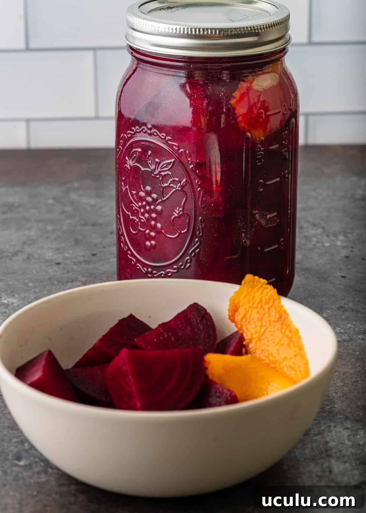 a bowl of pickled beets with a mason jar filled with more