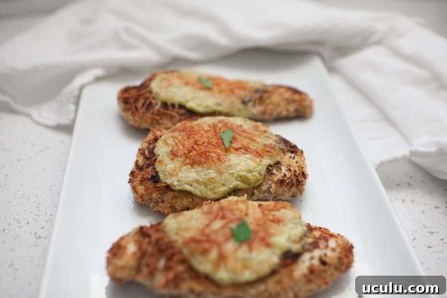 Cheesy Parmesan Chicken topped with herbs.