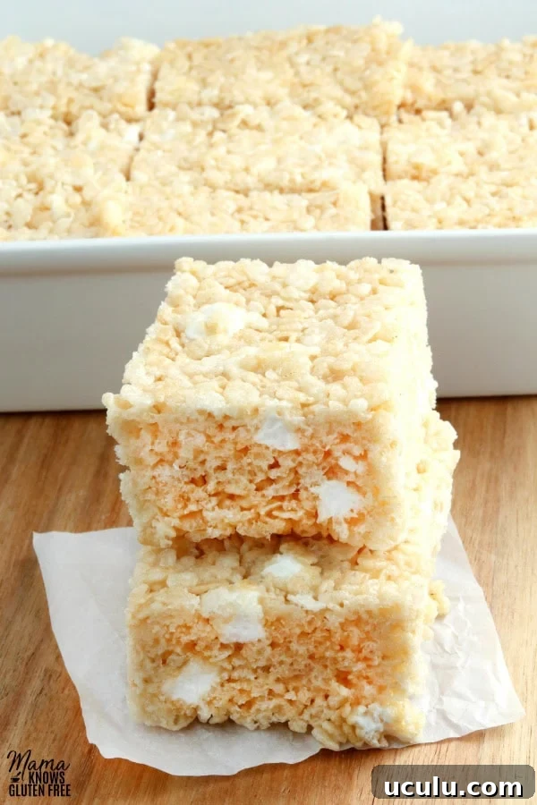 gluten-free rice krispies treats stacked on top of each other with the pan in the background