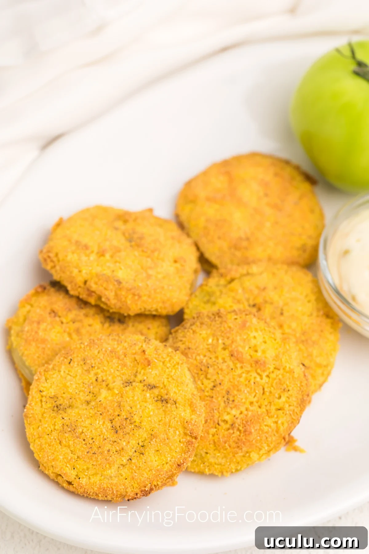 Air Fried Green Tomatoes on a white plate served with dipping sauce on the side.