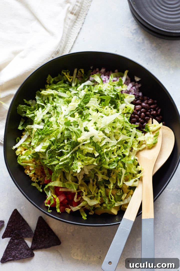lettuce in a bowl with other veggie taco salad ingredients