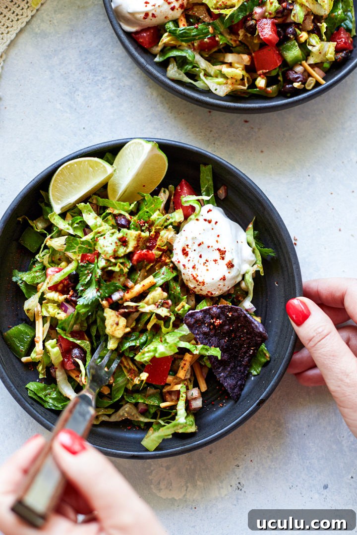 woman eating a plate of vegetarian taco salad