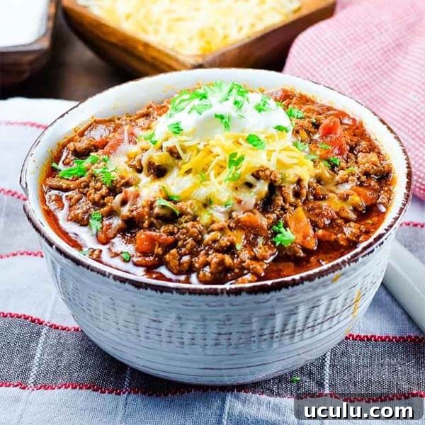 Low-Carb Instant Pot Recipes for Quick Weeknight Meals 12 keto low carb beef chili in a white bowl topped with melted cheese and sour cream