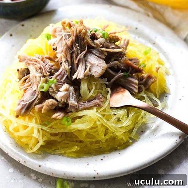Low-Carb Instant Pot Recipes for Quick Weeknight Meals 14 berry maple pork over spaghetti squash with a fork on a white plate with black speckles