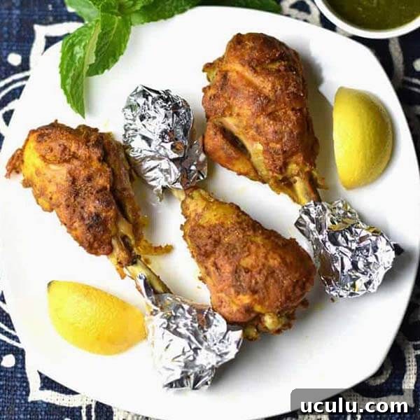 Low-Carb Instant Pot Recipes for Quick Weeknight Meals 4 Tandoori Chicken with foil on ends of bone on a white plate with lemon wedges