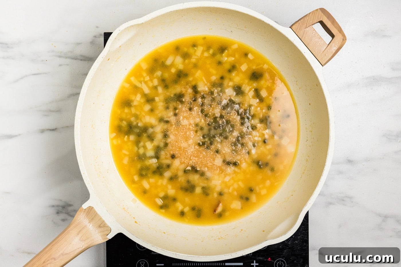 capers and broth in skillet
