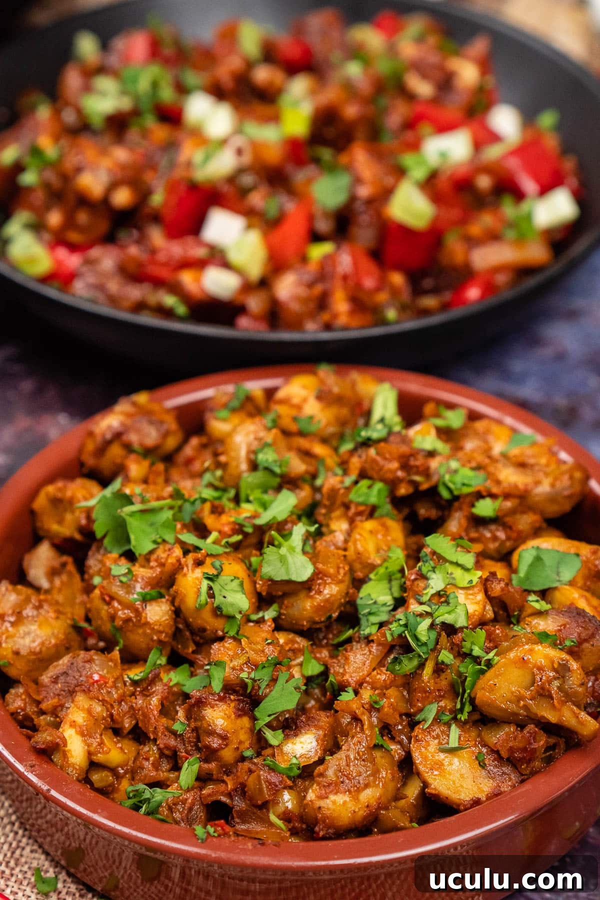 Indian Mushroom Bhaji Recipe | Flavorful Mushroom Curry Guide 2 Mushroom Bhaji Indian Curry in a tapas dish with fresh coriander on top and chilli paneer in the background