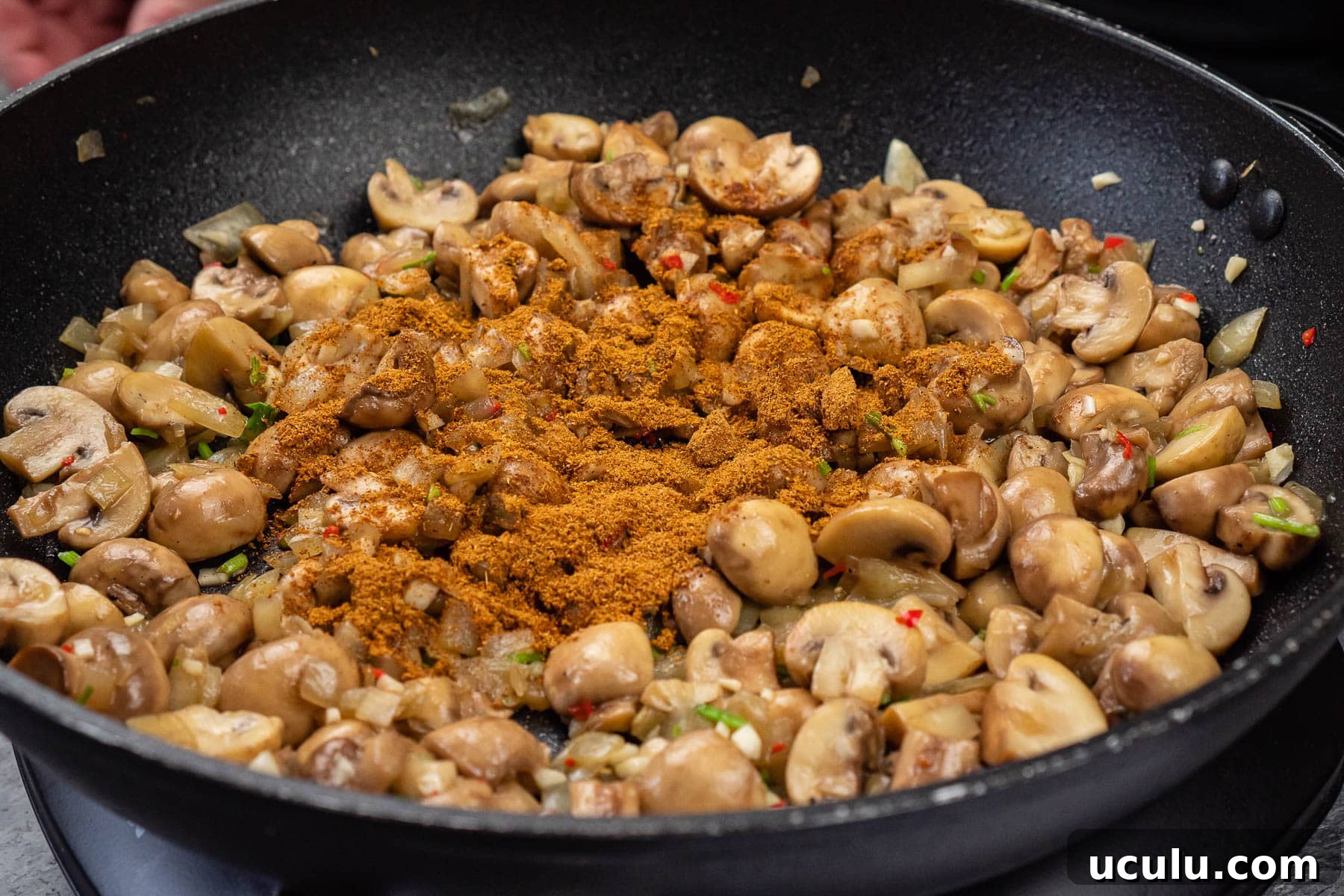 Indian Mushroom Bhaji Recipe | Flavorful Mushroom Curry Guide 18 Chopped mushrooms, chopped chilli, chopped onion, garlic, coriander stems and curry powder in a frying pan
