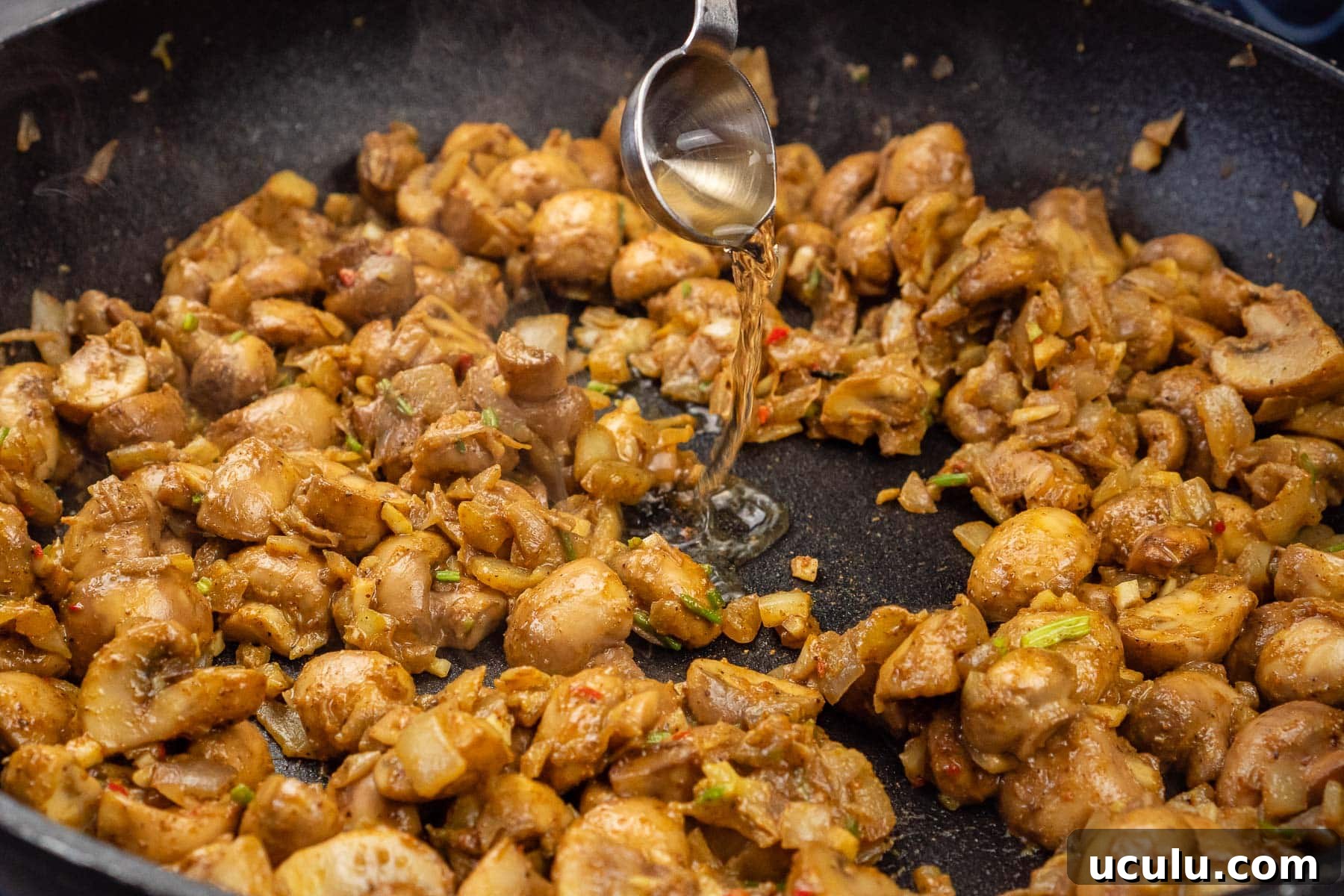 Indian Mushroom Bhaji Recipe | Flavorful Mushroom Curry Guide 20 Pouring white wine vinegar to the mushroom bhaji cooking in a frying pan