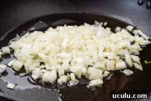 Indian Mushroom Bhaji Recipe | Flavorful Mushroom Curry Guide 6 Chopped onion being fried in oil in a pan