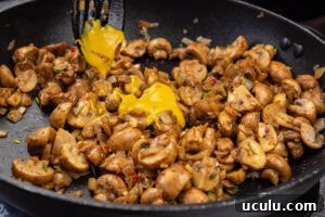 Indian Mushroom Bhaji Recipe | Flavorful Mushroom Curry Guide 10 English mustard being added to the mushroom bhaji cooking in a frying pan