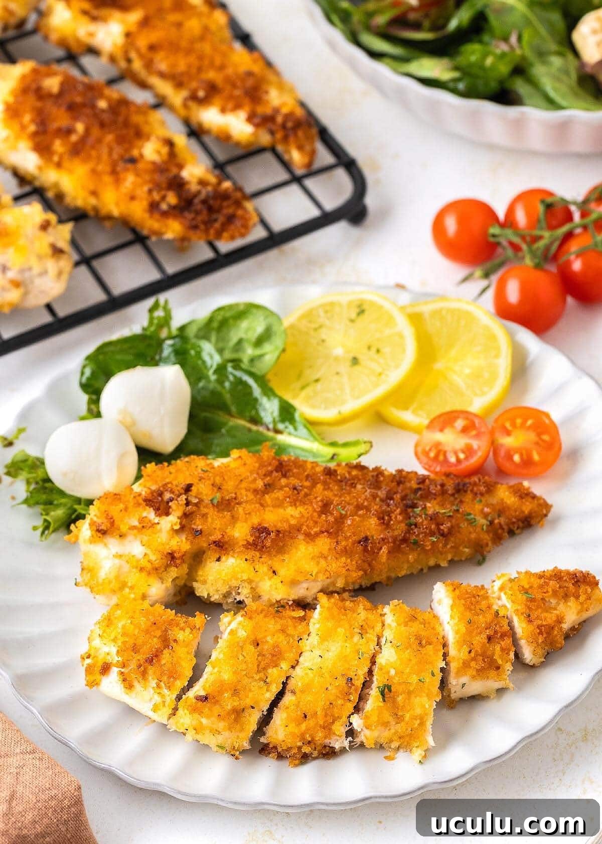 Crispy Pan-Fried Chicken Cutlets on a white plate with salad